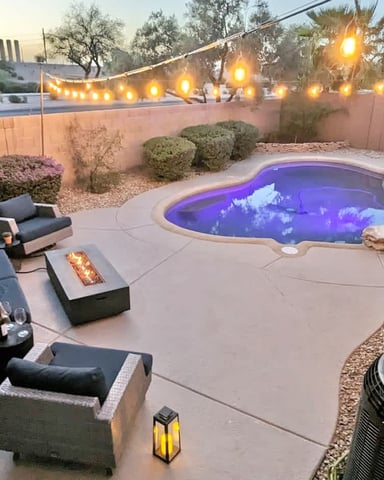 Heated pool lit at night with a fire table at a Desert Pine Stays home in Chandler
